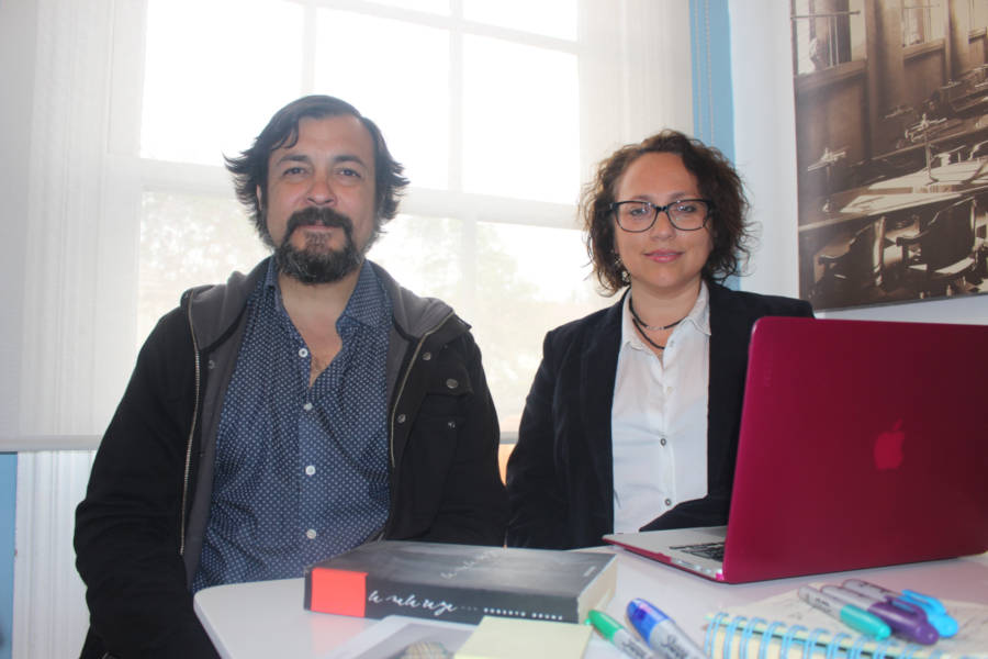 Roberto Bruna and Ana Arriagada sitting at a desk for a photo.