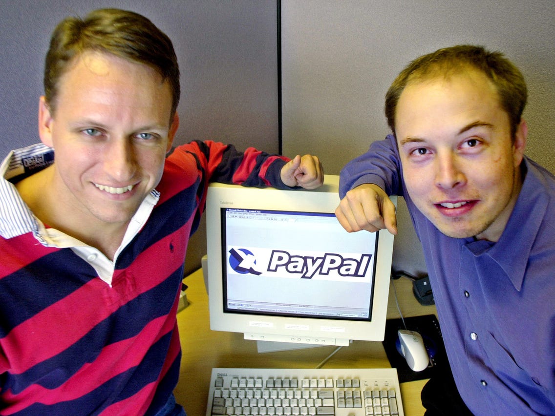 Picture of Peter Thiel and Elon Musk sitting around a computer, founders of PayPal.