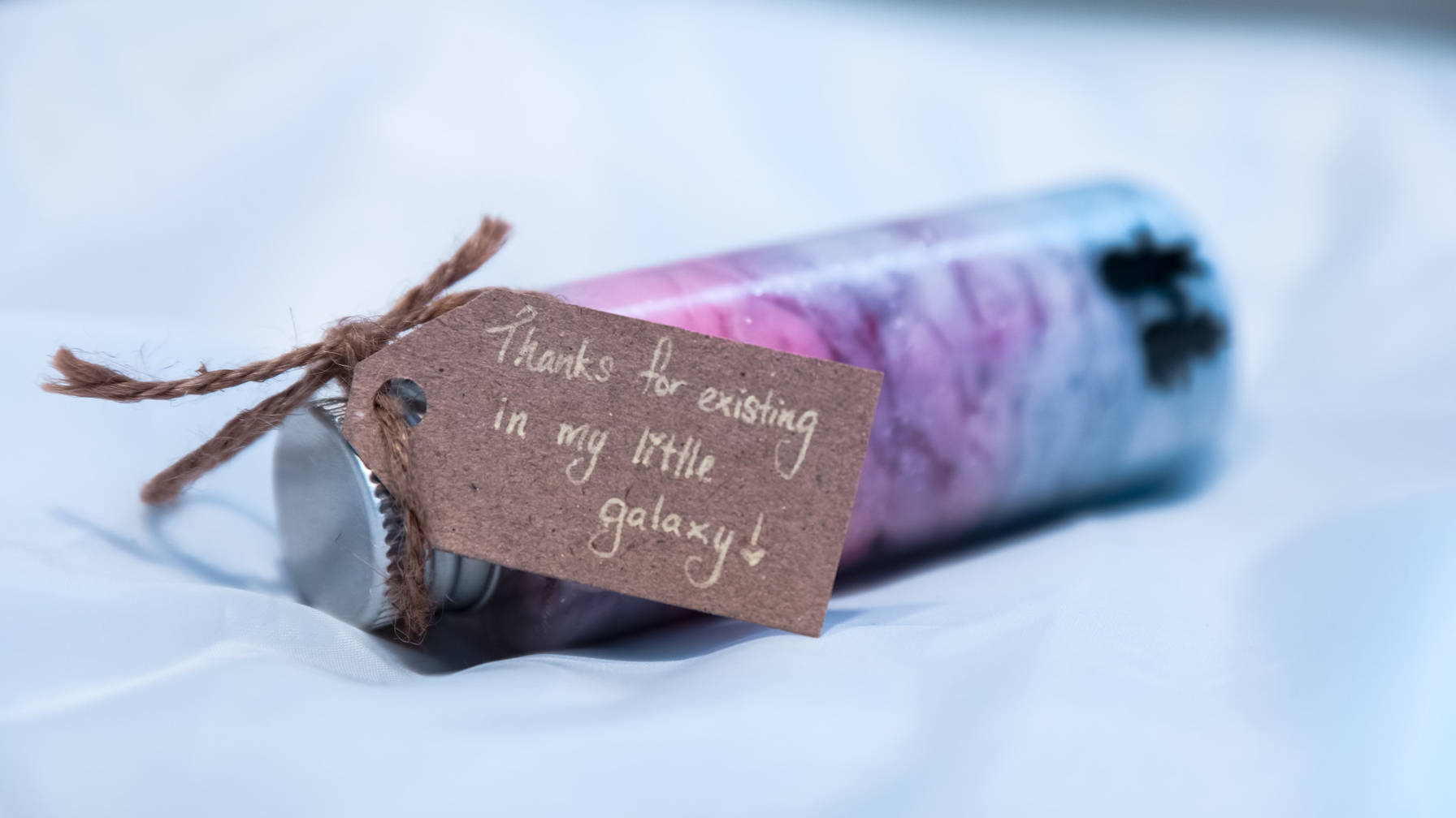 Decorative image of gift bottle with a tag that reads 'Thanks for existing in my little galaxy!'