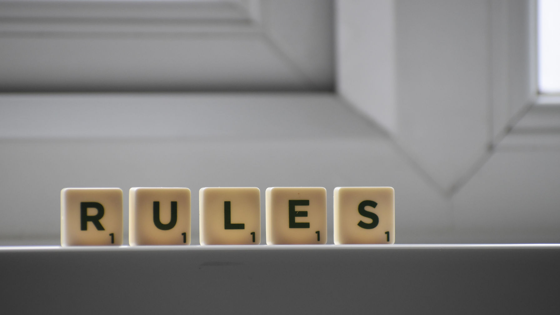 Decorative image that uses letters from the game of Scrabble to spell out 'RULES'.